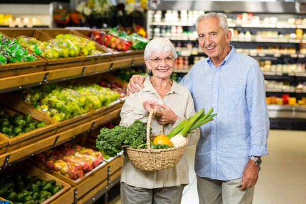 older couple at grocery store getting vegetables