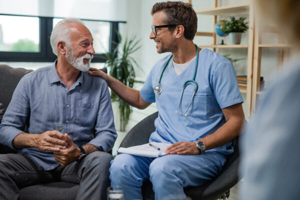 Happy doctor talking to senior male patient